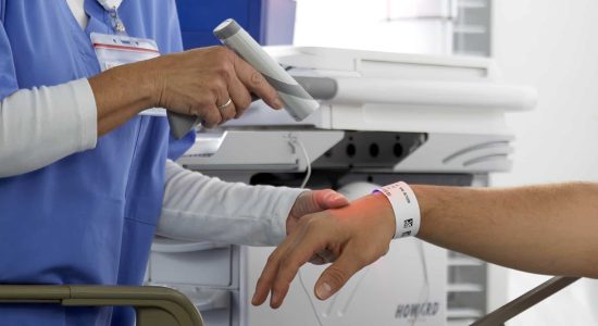 Nurse using code scanner barcode reader on patient